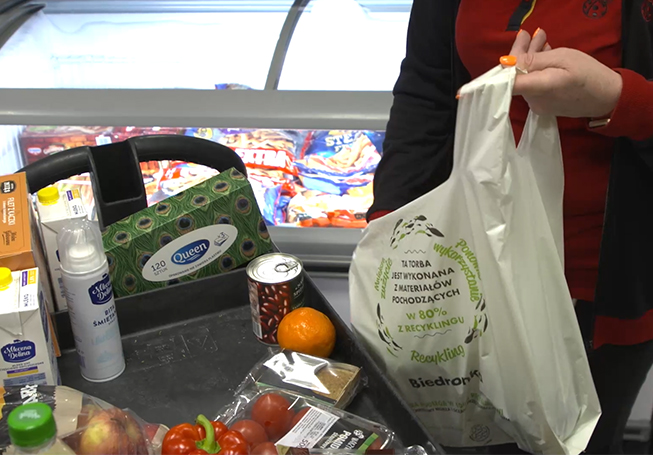 A person putting groceries inside a shopping bag (photo)