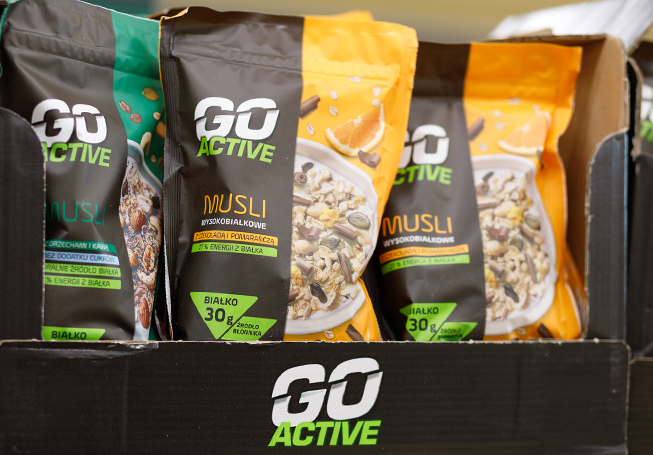 Close-up view of a cardboard box full of Muesli Go Active packages (photo)