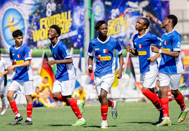 Five young football players in a football field, in motion (photo)