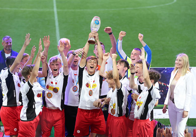Cheering footballers holding up a cup they just won (photo)