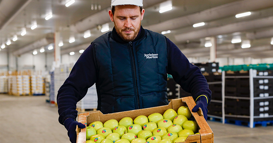 Employee carrying a crate of apples (photo)