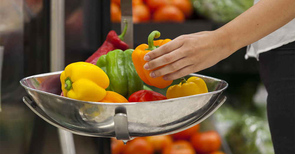 Customer's hand picking a yellow pepper (photo)