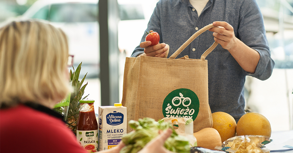 Person putting groceries inside a shopping bag (photo)