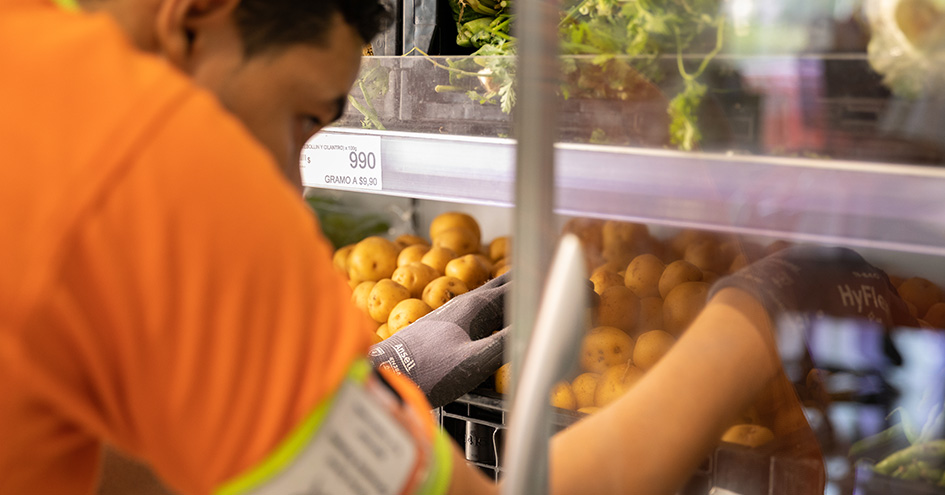 Store employee looking at a vegetable shelf (photo)