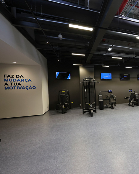 Interior of a gym, writing on the wall says "faz a mudanca a tua motivacao" (photo)