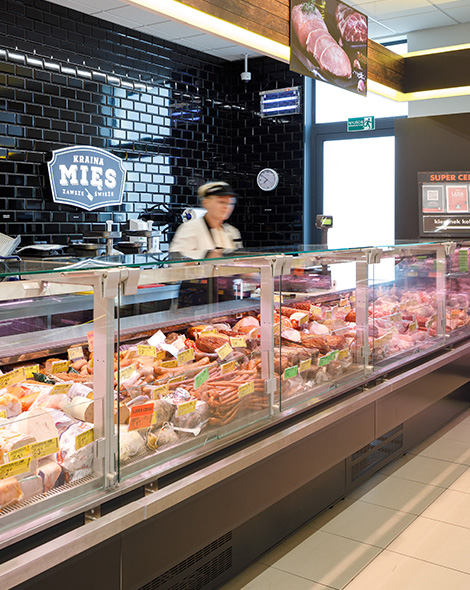 Store employee behind a meat counter (photo)