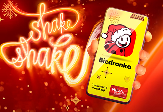 Poster with the Biedronka app on a mobile screen and a text saying "shake shake" in the background (photo)