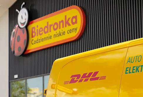 A DHL delivery car in front of a Biedronka store (photo)