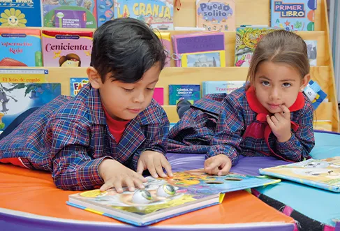 A young boy and a young girl looking and pointing at images in a children's book (photo)