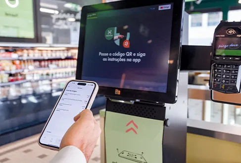 A customer using an app at the self-check-out desk (photo)