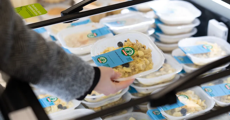 Close-up fo a customer taking a takeaway meal from a refrigerator at the store (photo)