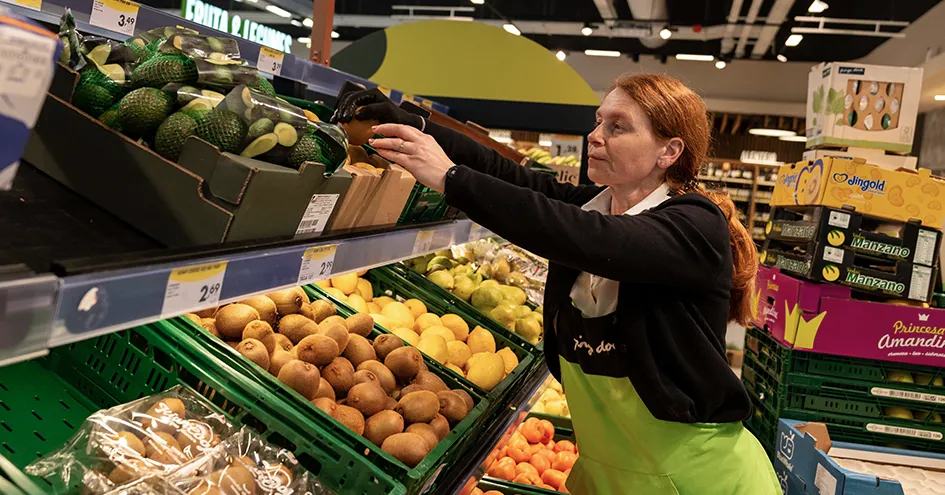 Pingo Doce employee restocking fruist in the fresh food section. (photo)