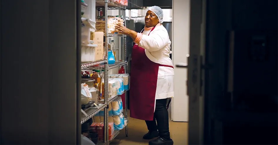 Employee arranging products in a supermarket shelf (photo)