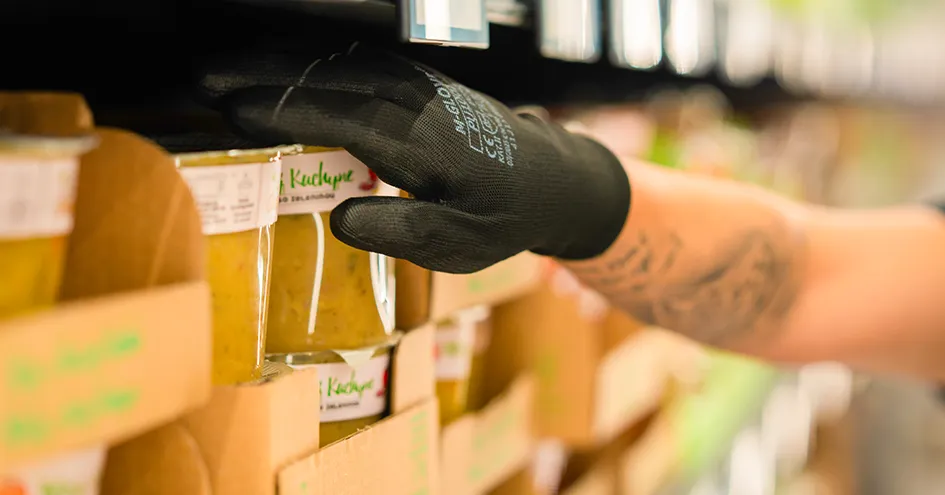 Close-up of an employee's hand touching a container of soup (photo)