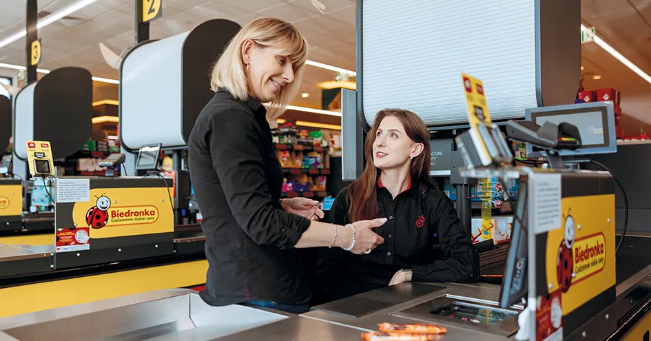 Two employees sitting at a Biedronka check-out counter (photo)