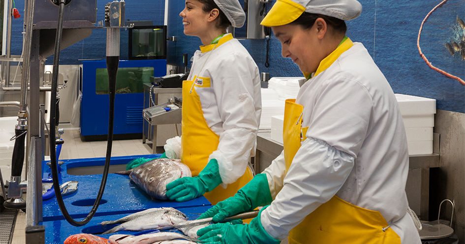 Duas colaboradoras sorridentes na peixaria (foto)