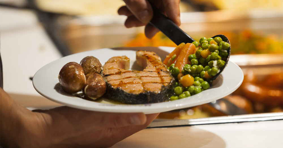 Grande plano de um prato com batatas, peixe e legumes (foto)