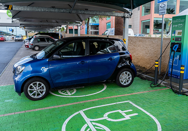 Carro elétrico a carregar no parque de estacionamento de um supermercado (foto)