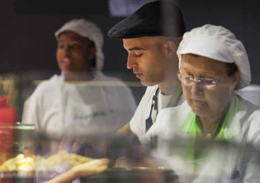 Colaboradores de diferentes idades a trabalhar na preparação de alimentos (foto)