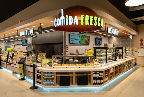 Um grande balcão de charcutaria com “comida fresca” no letreiro em cima. (foto)