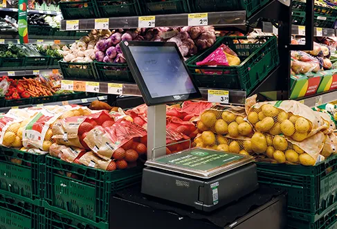 Caixas de legumes com batatas, cebolas e outros produtos em sacos de rede