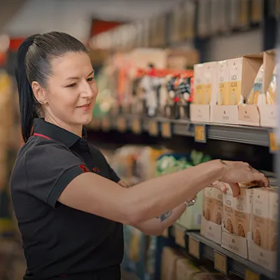 Colaborador a organizar produtos num linear de supermercado da Biedronka.