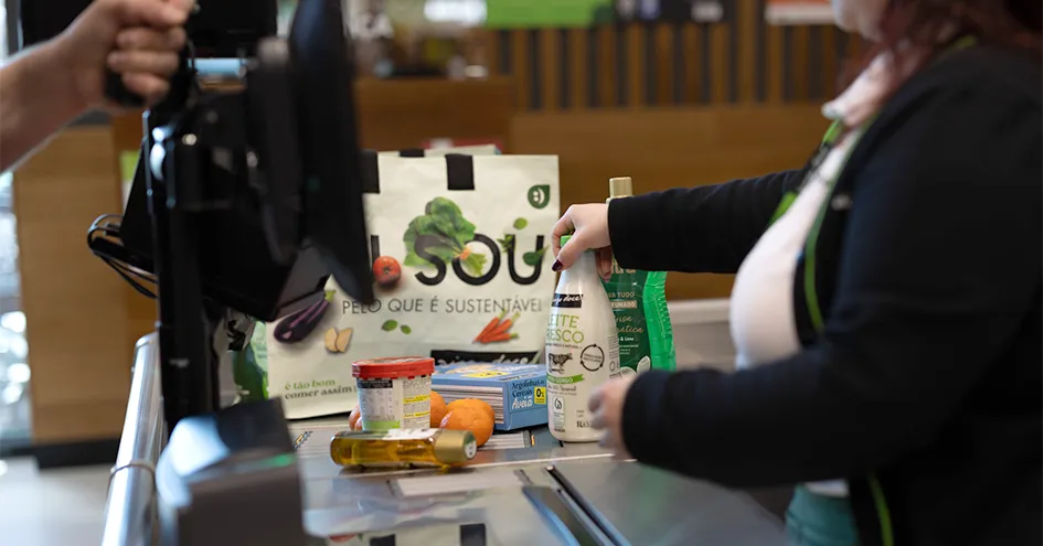 Grande plano de uma colaboradora do Pingo Doce a digitalizar artigos na caixa de pagamento (foto)