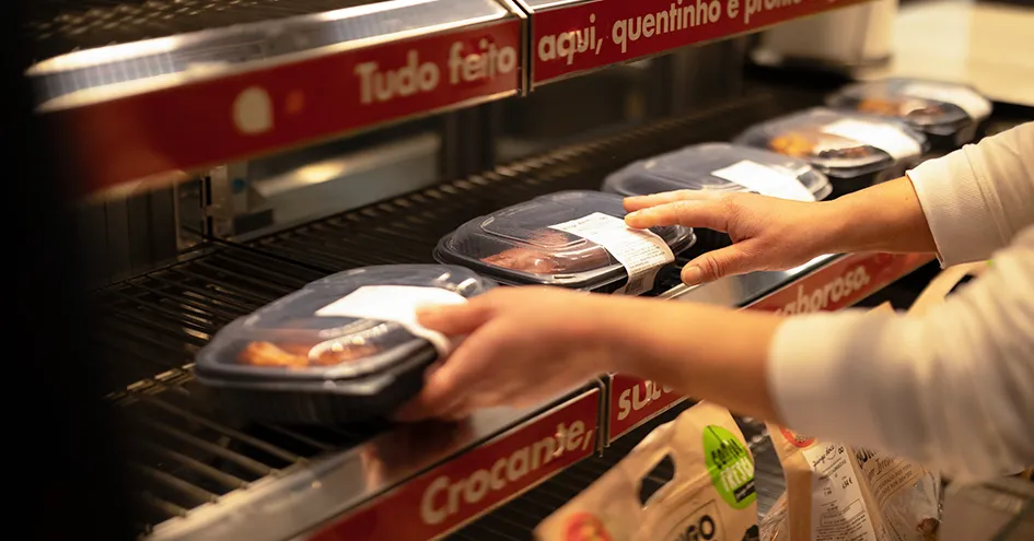 Grande plano de alguém a reabastecer comida quente pronta a levar (foto)